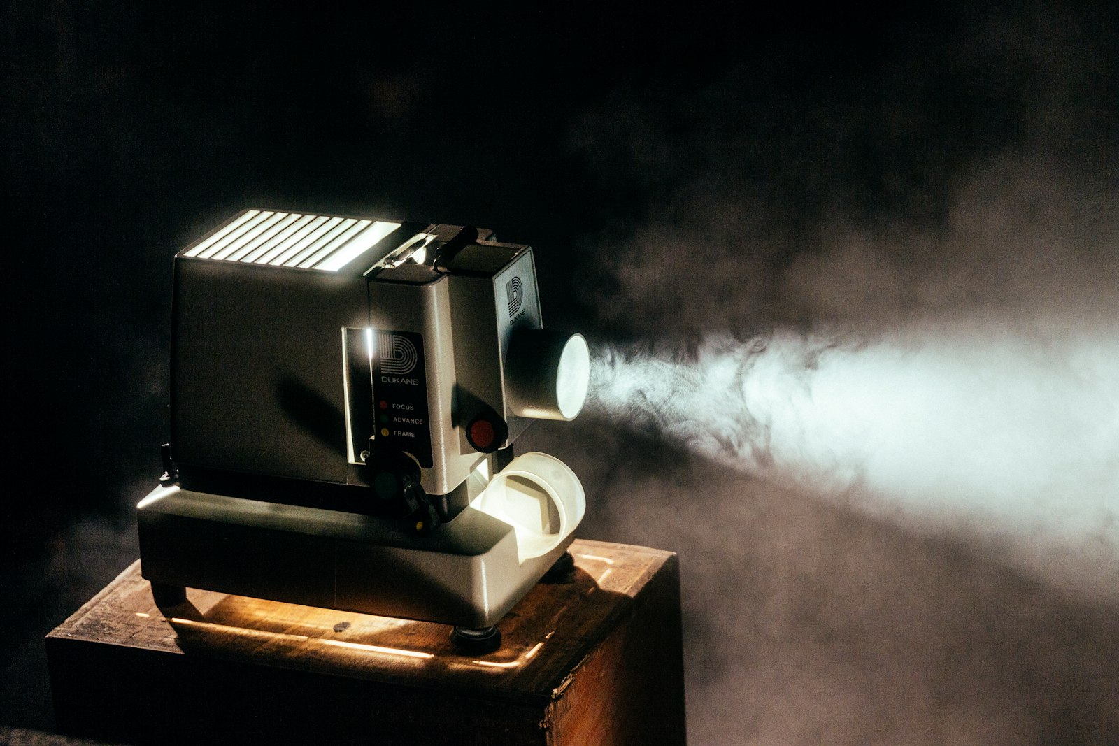 A film projector casting its beam through a dark, hazy room